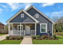 Charming home featuring a stylish gray exterior, covered front porch and well manicured lawn, creating inviting curb appeal at 345 Wellington Sw St, Atlanta, GA 30310