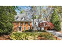 Stately brick home with dormer windows, well-manicured lawn and beautiful landscaping at 1285 Wesley Nw Pl, Atlanta, GA 30327