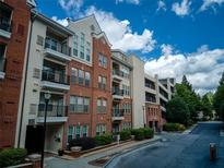 Condominium building featuring brick facade, balconies, and convenient parking deck for residents at 1850 Cotillion Dr # 4306, Dunwoody, GA 30338