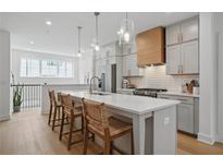 Modern kitchen featuring a large island, stainless steel appliances, pendant lighting, and light gray cabinetry at 230 New St # 2102, Decatur, GA 30030