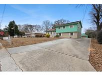 Inviting home featuring a well-manicured lawn and a long driveway with a detached garage at 6100 Prestige Valley Rd, Morrow, GA 30260