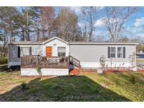 Charming single-story home featuring a cozy front porch and well-maintained landscaping at 91 East Meadow Ln, Conyers, GA 30012