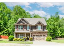 Charming two-story home with a stone-accented facade, landscaped yard, and attached two-car garage at 674 Chadmon Court Trce, Dacula, GA 30019
