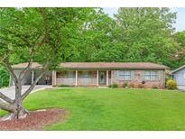 Charming single-story brick home featuring a covered porch and well-maintained front yard at 2585 Whisper Trail, Douglasville, GA 30135