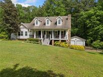 Charming two-story home with inviting front porch, stone chimney, and lush landscaping at 1822 Morgan Rd, Canton, GA 30115