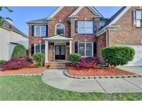 Charming two-story brick home with a manicured lawn and beautiful landscaping at 1943 Blue Heron Way, Lawrenceville, GA 30043