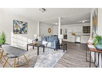 Spacious living room featuring a blue sofa, gray chairs, modern art, and stylish decor at 4781 Brownsville Rd, Powder Springs, GA 30127