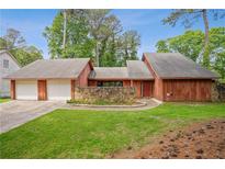 Charming exterior view of home with attached garage, stone accent wall, and lush green lawn at 6134 Silver Spur Dr, Lithonia, GA 30058