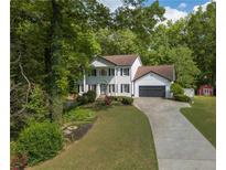 Charming two-story home featuring a well-manicured lawn and a long driveway leading to a two-car garage at 731 Sacketts Ct, Lawrenceville, GA 30043