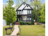 Charming two-story home with modern black and white exterior and well-manicured front yard at 1676 Carroll Nw Dr, Atlanta, GA 30318