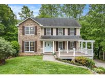 Charming two-story home with a stone facade and a welcoming front porch, nestled among lush trees and landscaping at 4754 Kelley Se Ct, Mableton, GA 30126