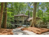 Beautiful two-story home with a deck nestled amongst lush trees at 1050 Mountain Creek Trl, Atlanta, GA 30328