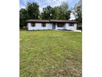 Charming single-story home with freshly painted white brick, a vibrant blue door, and a well-manicured green lawn at 4074 Green Hawk Trl, Decatur, GA 30035