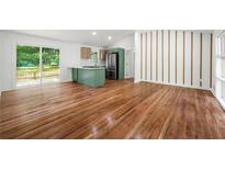 Bright living room featuring hardwood floors, modern kitchen, and sliding glass doors to the deck at 1760 Detroit Nw Ave, Atlanta, GA 30314