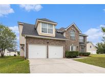 Two-story brick home with a two-car garage and well-maintained lawn on a sunny day at 4207 Fortune Pt, South Fulton, GA 30349