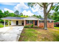 Charming brick home featuring a carport, black shutters, and a well-maintained front yard with mature trees and blooming shrubs at 6213 Cherry Ln, Douglasville, GA 30134