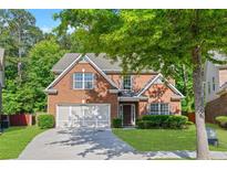Charming brick home with a well-manicured lawn, two-car garage, and mature trees in a Gathering-friendly neighborhood at 4353 Pond Edge Rd, Snellville, GA 30039