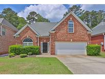 Charming red brick home with a manicured lawn and a two-car garage at 735 Scenic Creek Dr, Lawrenceville, GA 30046
