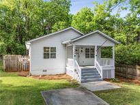 Charming cottage-style home with a welcoming front porch and well-maintained lawn surrounded by mature trees at 1596 Foote Ne St, Atlanta, GA 30307