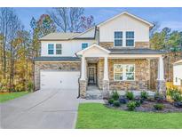 Charming two-story home with a stone and white shingle exterior, complemented by a well-maintained lawn and landscaping at 3686 Bills Cir, Atlanta, GA 30331