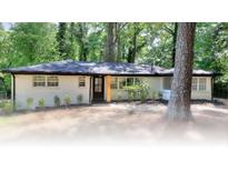 Charming single-story home featuring painted brick, black trim and a lush green yard at 2094 Shamrock Dr, Decatur, GA 30032
