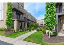 Charming brick townhomes with black metal balconies, lush landscaping, and inviting sidewalks at 1032 Robert Smalls Way, Atlanta, GA 30318