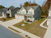 Beautiful two-story home with a well-manicured lawn and mature trees in a quiet neighborhood at 221 Eleanora Way, Loganville, GA 30052