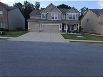 Charming two-story home with a well-maintained lawn and a spacious three car garage at 221 Eleanora Way, Loganville, GA 30052