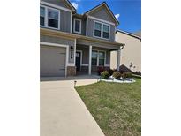 Charming two-story home with attached garage and manicured lawn and garden at 221 Eleanora Way, Loganville, GA 30052