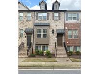 Charming townhome featuring a brick facade, inviting entrance, and well-maintained landscaping at 4487 Kerrington Ave, Sugar Hill, GA 30518
