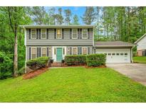 Charming two-story home featuring a well-manicured lawn, a light blue front door and an attached two-car garage at 4536 Mountain Creek Ne Dr, Roswell, GA 30075