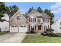Charming brick two-story home featuring a well-manicured lawn and a two-car garage at 139 Ardsley Run, Canton, GA 30115