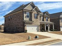 Beautiful two-story brick home with a two-car garage and manicured front lawn at 3566 Andover Way, Buford, GA 30519