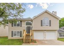 Charming two-story home featuring a two-car garage, inviting entrance, and well-maintained landscaping at 3022 Stonebridge Creek Dr, Lithonia, GA 30058