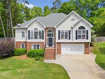 Charming two-story home featuring a brick and stucco facade, black shutters, and a well-manicured lawn at 47 Centerport Dr, White, GA 30184