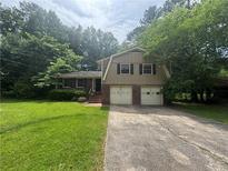 Charming two-story home featuring a brick and vinyl facade, a two-car garage, and a well-manicured front lawn at 4135 Moore Rd, Conley, GA 30288