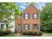 Charming brick front home with a manicured lawn, lush greenery and complemented by dark shutters at 855 Cedar Bluff Ct, Marietta, GA 30062