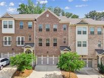 Charming brick townhome featuring a two-car garage and well-maintained landscaping at 1327 Rosen Rd, Brookhaven, GA 30319
