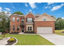 Charming two-story brick home with a well-manicured lawn and attached two-car garage at 1934 Acorn Ln, Dacula, GA 30019