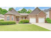 Charming brick home with a well-manicured lawn and a two-car garage, perfect for Gathering living at 3020 Crooked Stick Dr, Cumming, GA 30041