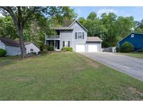 Charming two-story home featuring a two-car garage, second story balcony, and well-manicured front lawn at 4971 Sharp Way, Duluth, GA 30096