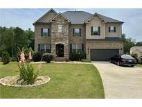 Beautiful two-story home with manicured lawn, stone accents, and attached two-car garage at 292 Aylesbury Blvd, Mcdonough, GA 30252