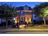 Beautiful two-story brick home featuring manicured landscaping, warm exterior lighting, and classic architectural details at 7165 Winthrop Rd, Alpharetta, GA 30005
