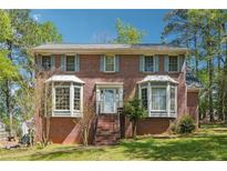 Charming brick home with well-manicured lawn and traditional bay windows, perfect for suburban living at 1366 Maple Ridge Dr, Suwanee, GA 30024