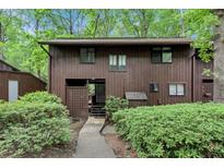 Two story house with brown siding and well-kept landscaping, situated in a serene, wooded setting at 1668 Terrell Ridge Se Dr, Marietta, GA 30067