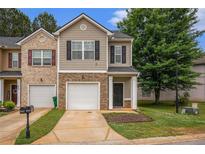 Inviting townhome with a well-manicured lawn, brick accents and a one-car garage at 3565 Brycewood Dr, Decatur, GA 30034