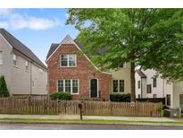 Charming two-story home with a brick facade and a well-manicured front yard and a wooden fence at 2685 Grady Se St, Smyrna, GA 30080