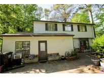 Charming two-story home featuring light siding, a cozy back patio, and lush greenery at 5041 Rockborough Trl, Norcross, GA 30071