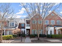 Beautiful brick townhome featuring manicured landscaping and mature trees in an inviting neighborhood at 8730 Parker Pl, Roswell, GA 30076