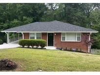 Charming brick home with a well-maintained lawn and covered parking at 2833 Oldknow Nw Dr, Atlanta, GA 30318